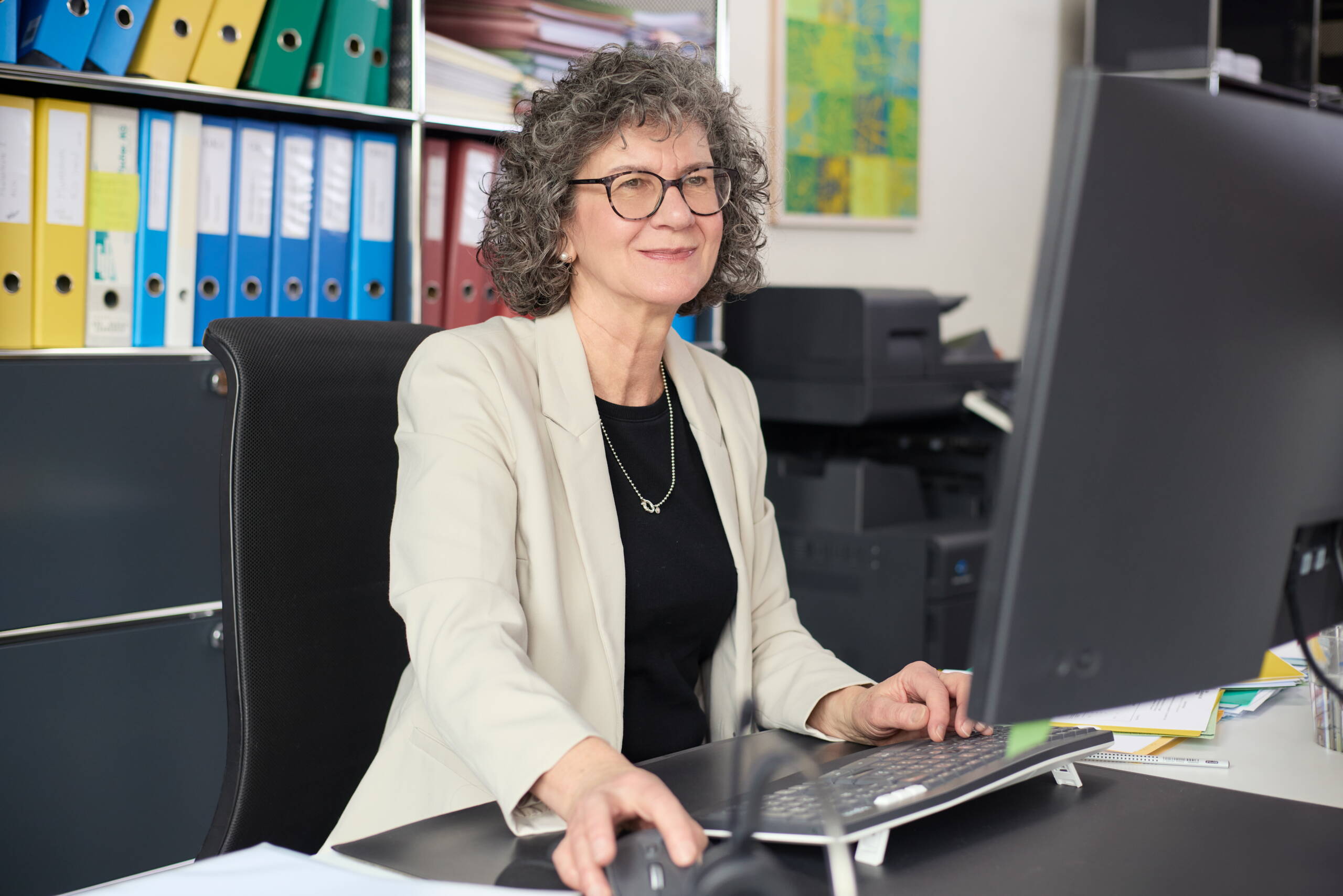 Frau mit dunklen Haaren, welche einer Kundin etwas erklärt.
