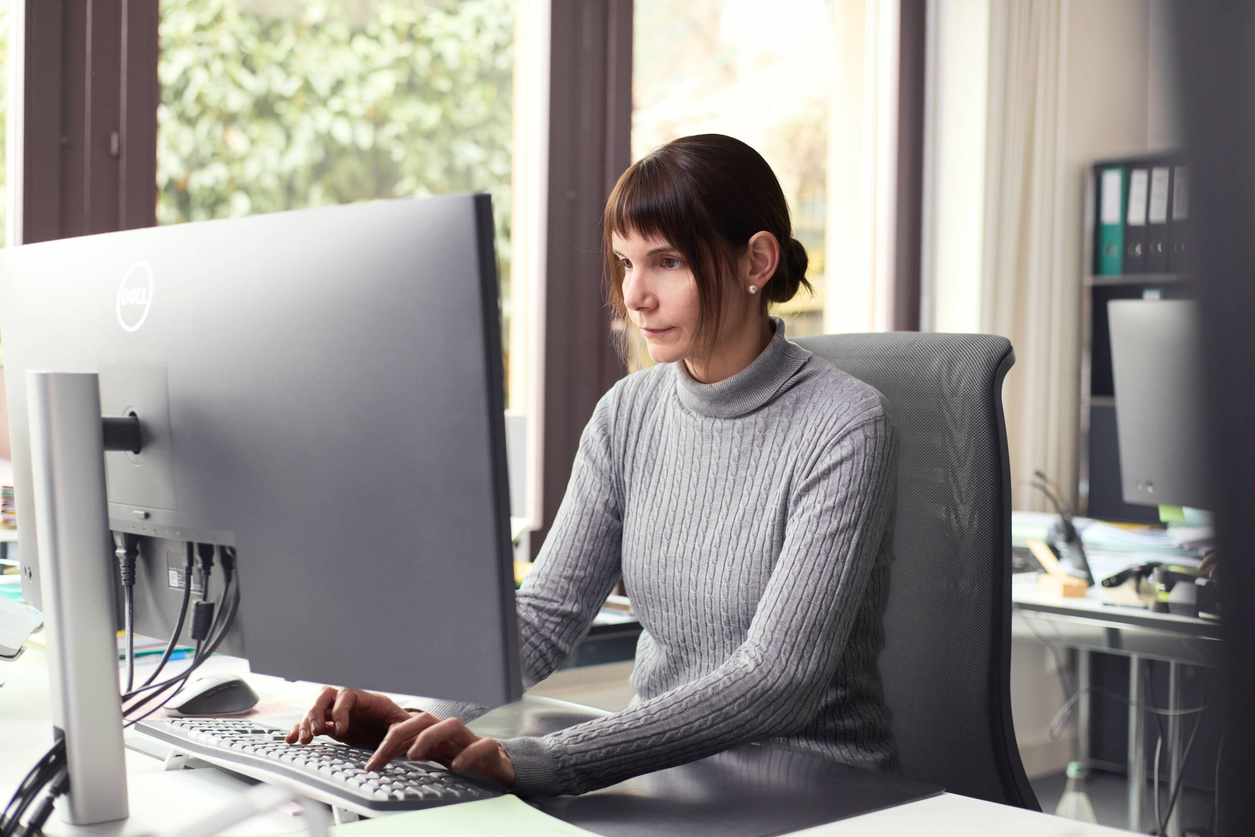 Frau mit hellbraunen Haaren am Telefon